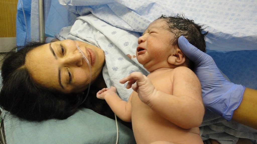Newborn being shown to mother right after delivery 